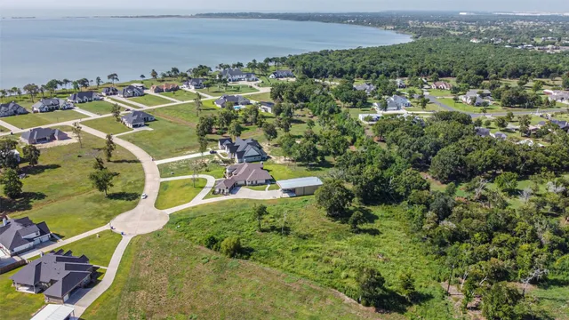 an aerial view of a house with a yard and lake view