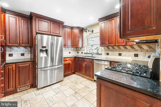 a kitchen with stainless steel appliances granite countertop a refrigerator sink and cabinets