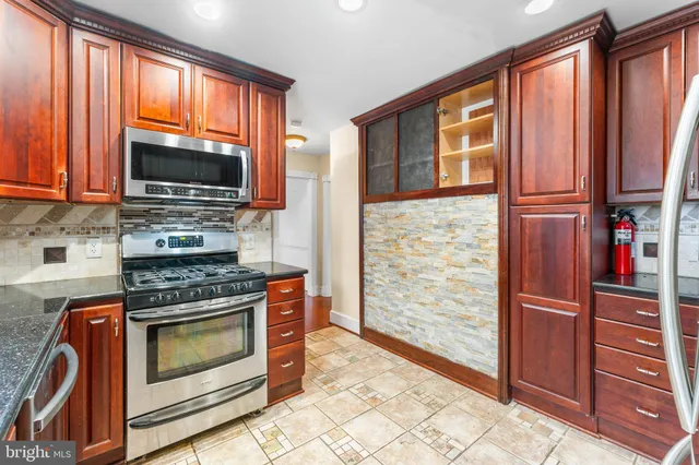 a kitchen with wooden cabinets and a stove top oven
