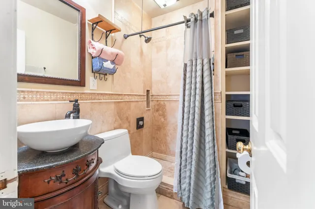 a bathroom with a granite countertop sink toilet and shower