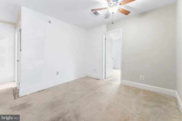 an empty room with a ceiling fan and a window