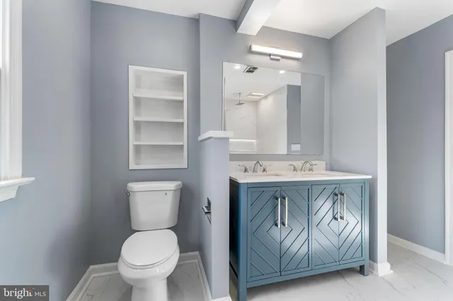 a bathroom with a sink a toilet and a mirror