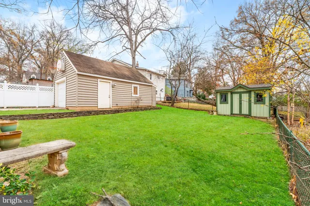 a front view of a house with a garden and trees