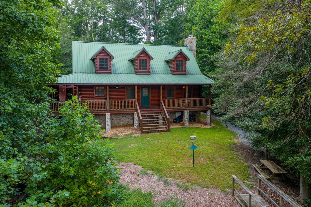 846 Twiggs Ferry Road Hartfield, VA 23071 - Photo 27 of 28 Log home featuring stairway, covered porch, a front yard, a chimney, and a metal roof