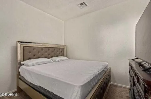 a bed sitting in a bedroom next to a window