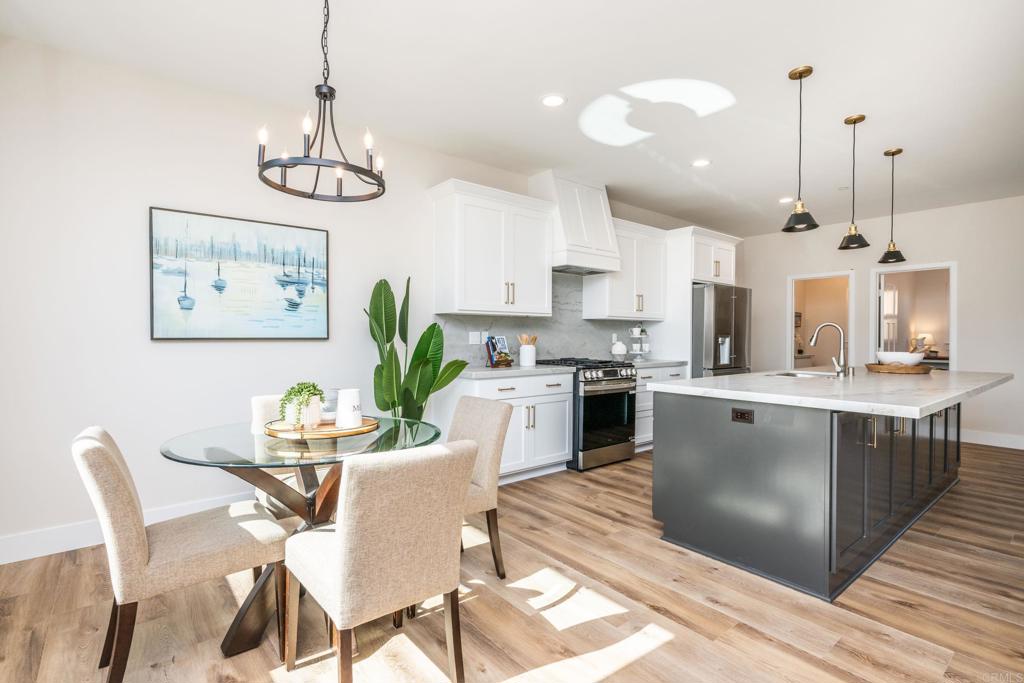 1904 Grey Rabbit Hollow Lane Fallbrook, CA 92028 - Photo 18 of 67 a kitchen with stainless steel appliances kitchen island granite countertop a dining table chairs and white cabinets