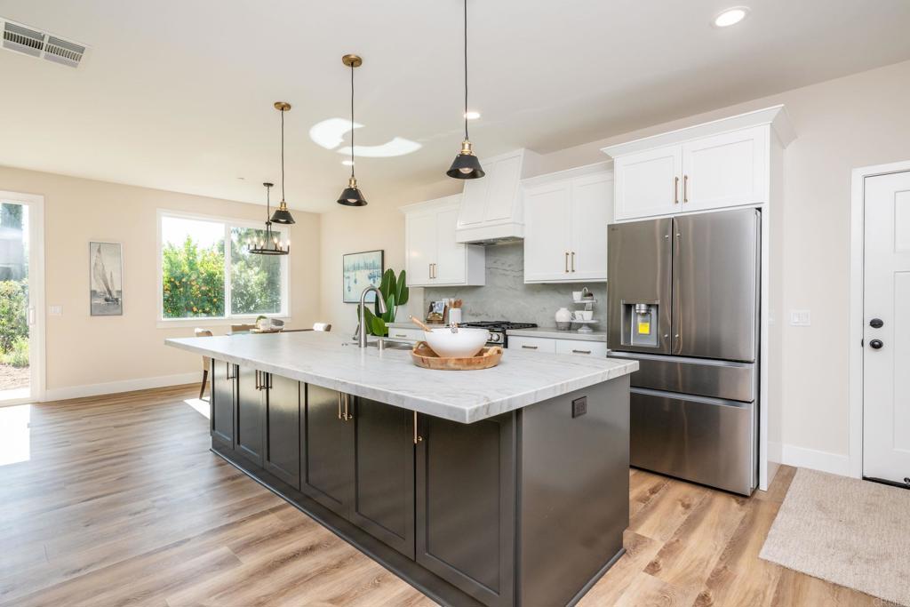 1904 Grey Rabbit Hollow Lane Fallbrook, CA 92028 - Photo 21 of 67 a kitchen with stainless steel appliances granite countertop a sink a stove a refrigerator and island with wooden floor