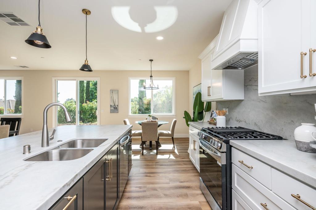 1904 Grey Rabbit Hollow Lane Fallbrook, CA 92028 - Photo 23 of 67 a kitchen with stainless steel appliances a stove a sink a oven a dining table and chairs with wooden floor
