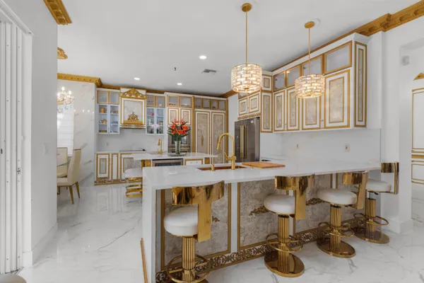 a kitchen with a sink appliances and chairs