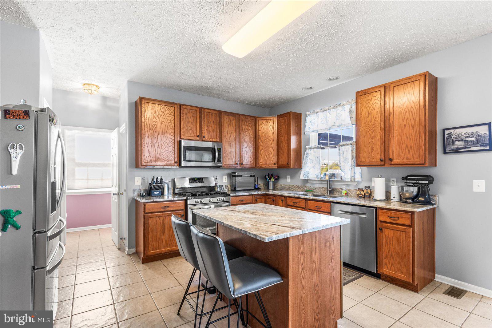 20 Sydney Drive Hanover, PA 17331 - Photo 26 of 73 a kitchen with stainless steel appliances granite countertop a stove top oven a sink dishwasher a dining table and chairs with wooden floor