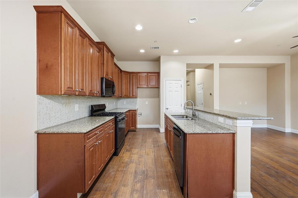 4673 Cecile Road Plano, TX 75024 - Photo 14 of 29 a kitchen with stainless steel appliances granite countertop wooden cabinets a stove top oven a sink and dishwasher