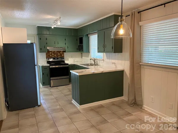 a kitchen with stainless steel appliances granite countertop a sink a stove a refrigerator and a refrigerator