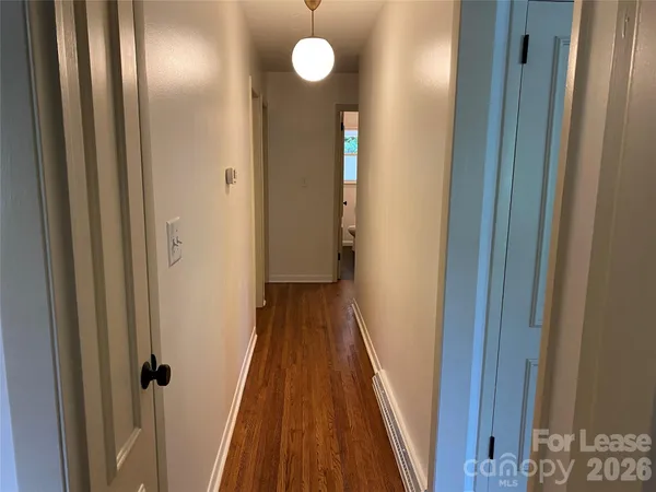 a view of a hallway with wooden floor