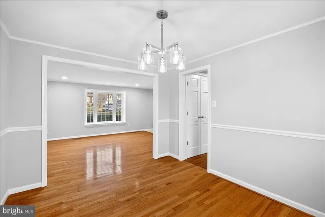 a view of an empty room with wooden floor and stairs