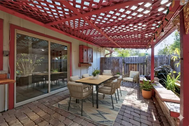 a view of a dinning table and chairs in patio with wooden fence
