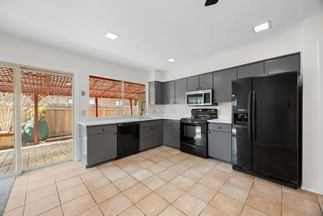 a kitchen with granite countertop a refrigerator and a stove top oven