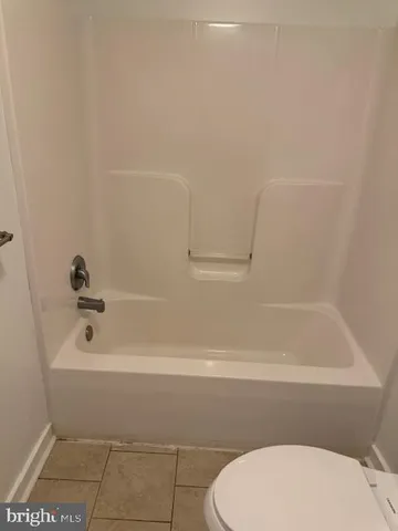 a bathroom with a granite countertop toilet and a sink