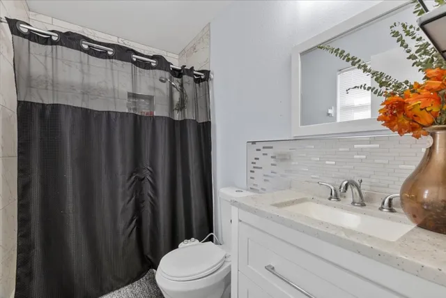 a bathroom with a granite countertop sink toilet and shower