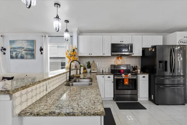 a kitchen with granite countertop a refrigerator and a stove top oven