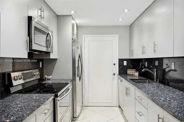 a kitchen with granite countertop a stove and a refrigerator