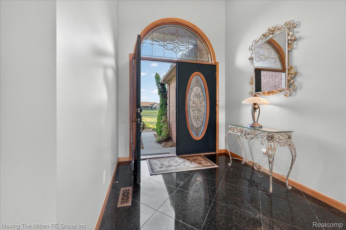39750 Willow Road New Boston, MI 48164 - Photo 3 of 68 Entryway featuring a decorative arch-top door with leaded glass, dark tile flooring, and light wall finishes