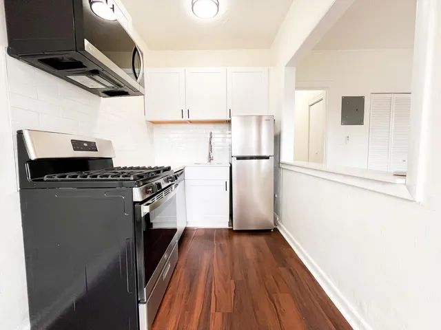 a kitchen with a refrigerator and a stove top oven