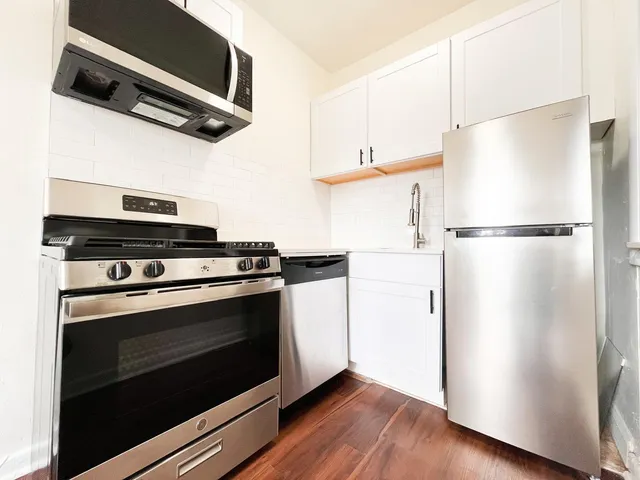 a white refrigerator freezer and a wooden floor