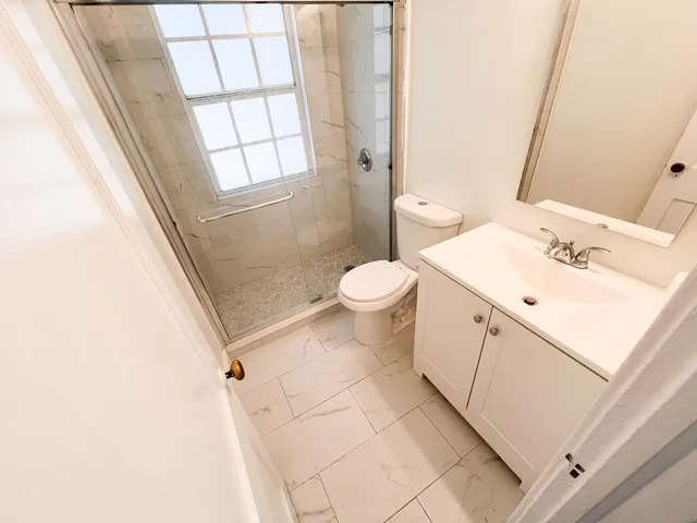 a bathroom with a sink toilet and shower