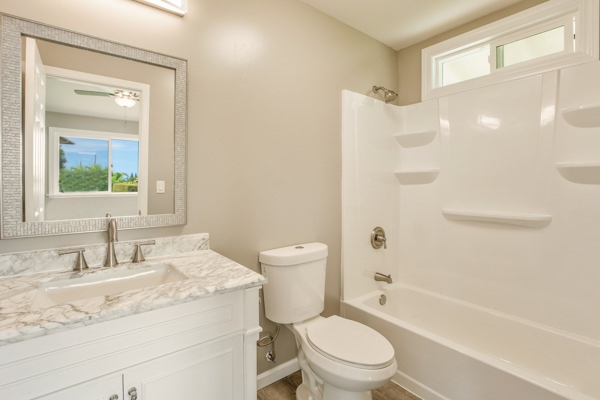 4722 Mailihuna Road Kapaa, HI 96746 - Photo 17 of 22 a bathroom with a granite countertop toilet a sink and a bathtub