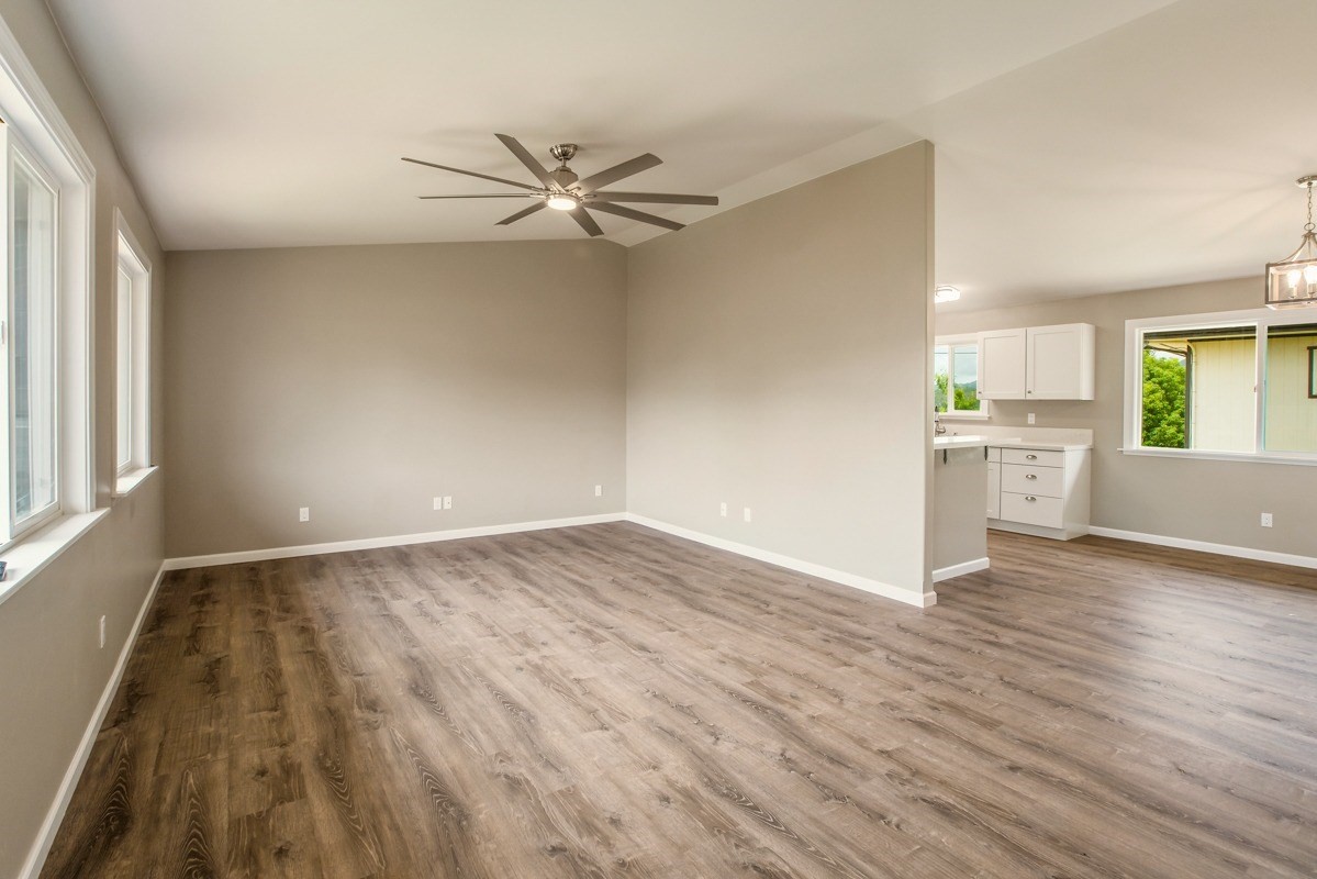 4722 Mailihuna Road Kapaa, HI 96746 - Photo 7 of 22 an empty room with wooden floor a ceiling fan and windows