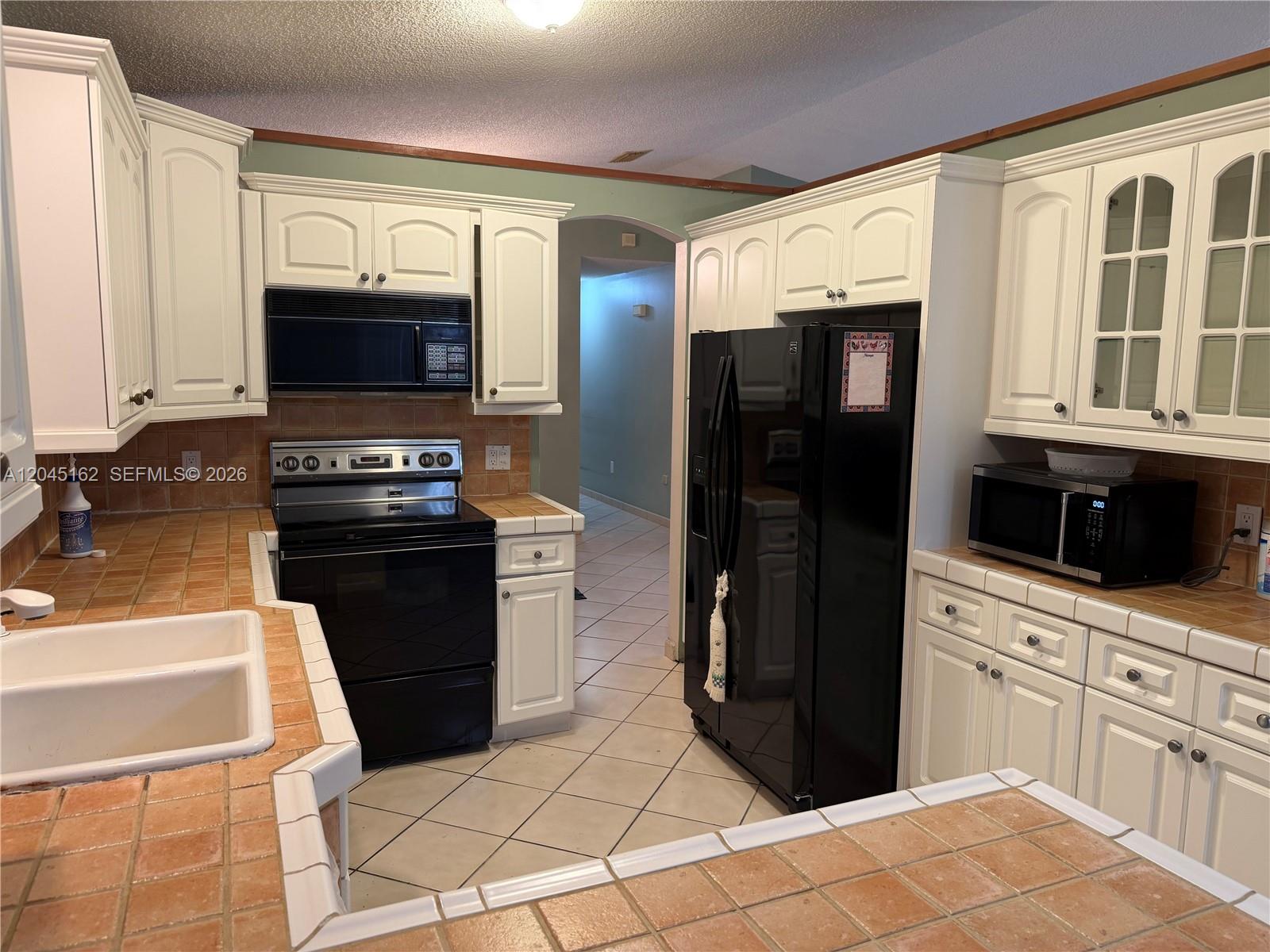 3262 Southwest 139th Place Miami, FL 33175 - Photo 9 of 36 a kitchen with a refrigerator stove and sink