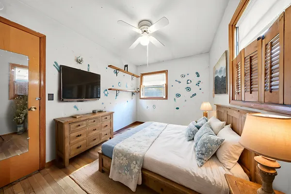 a bedroom with a large bed and a flat tv screen on dresser