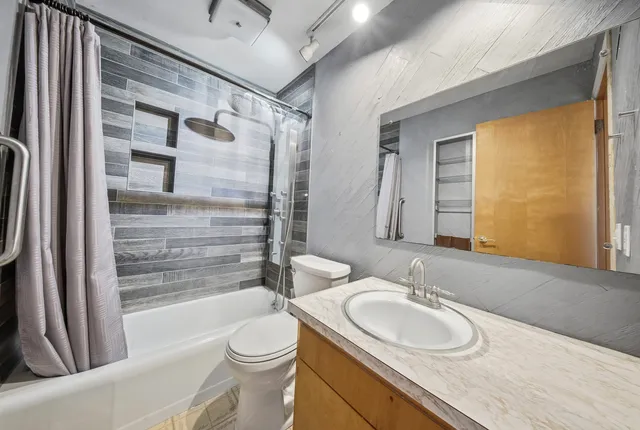 a bathroom with a sink a toilet and shower