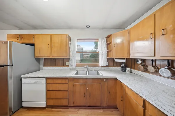 a kitchen with sink a window and chairs