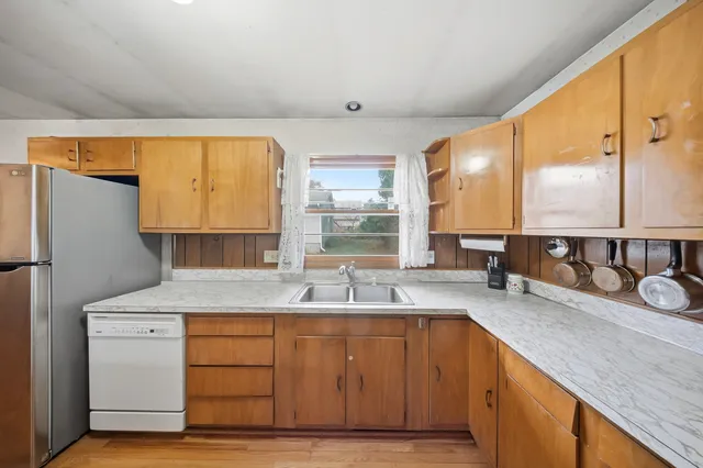 a kitchen with sink a window and chairs