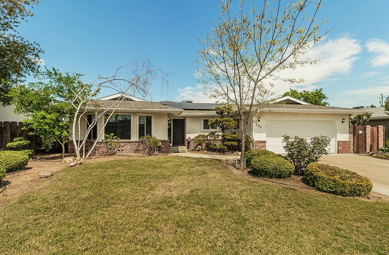 596 West Herbert Avenue Reedley, CA 93654 - Photo 1 of 30 a front view of a house with a garden and outdoor seating