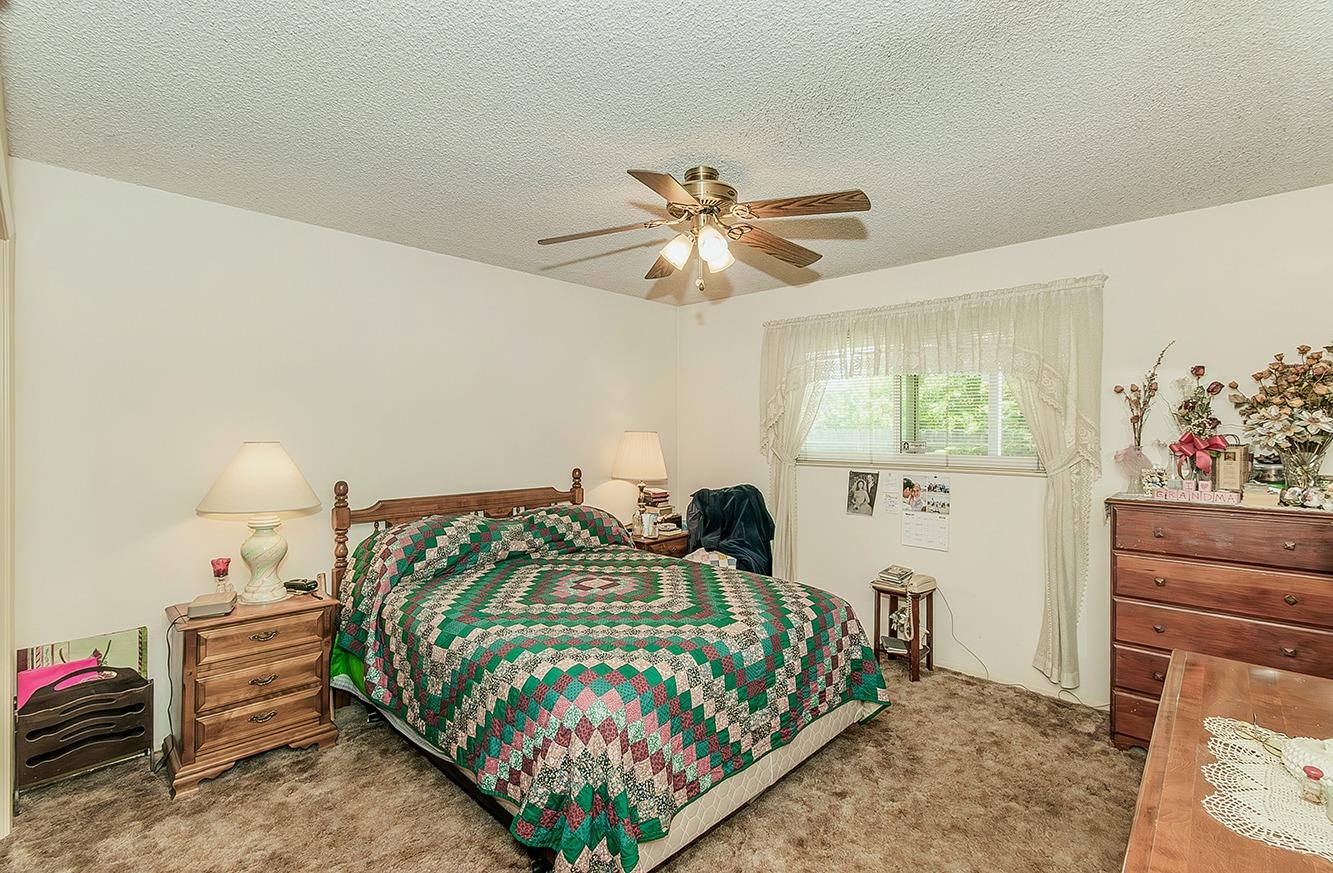 596 West Herbert Avenue Reedley, CA 93654 - Photo 22 of 30 a bedroom with a bed and a chandelier
