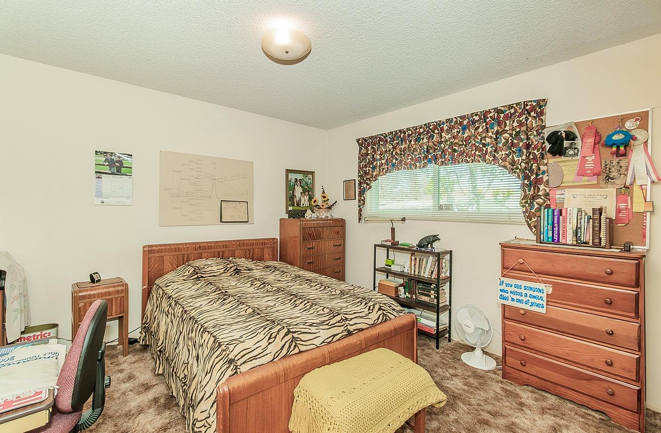 596 West Herbert Avenue Reedley, CA 93654 - Photo 25 of 30 a bedroom with a bed and a dresser with wooden floor