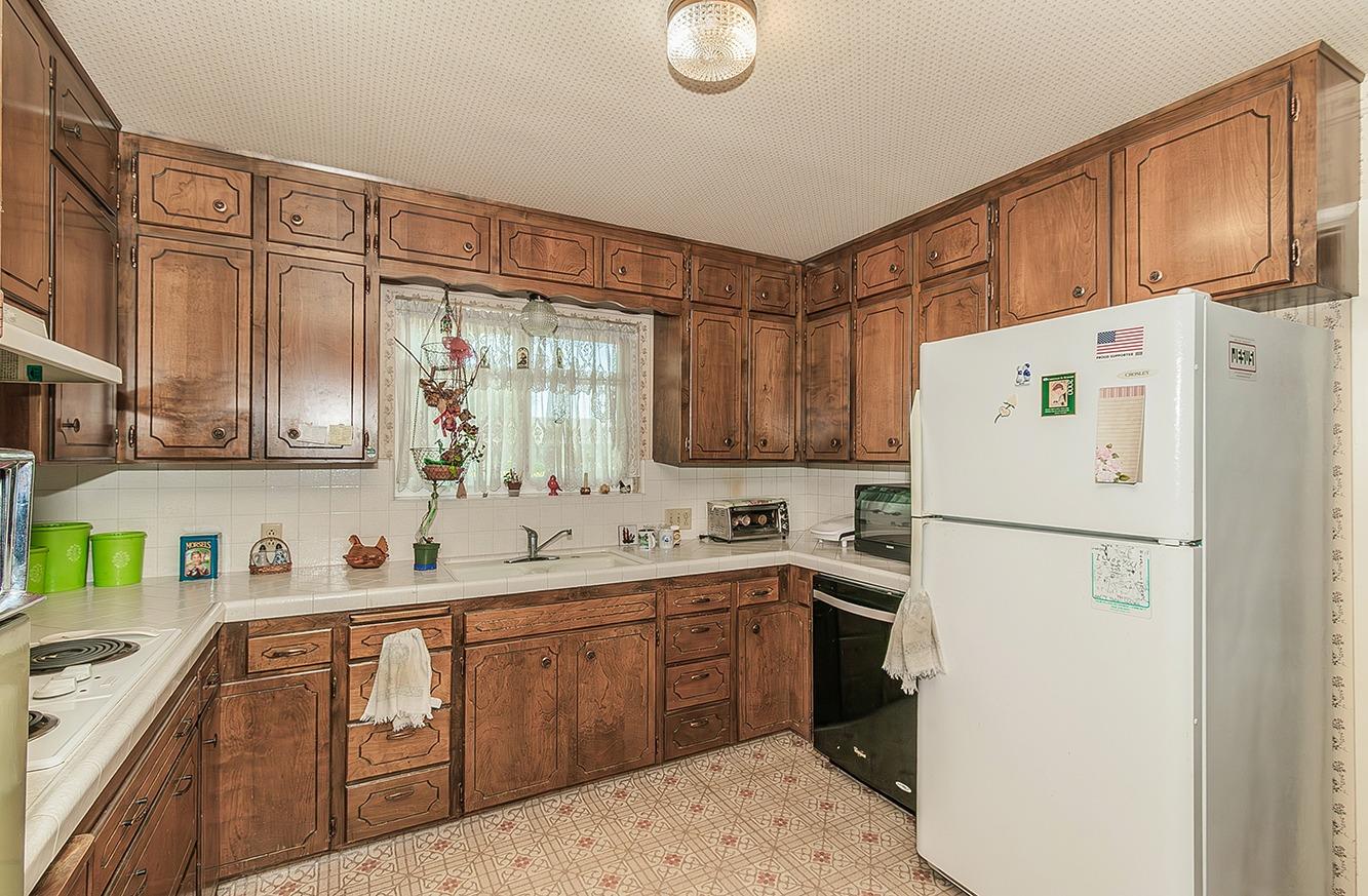 596 West Herbert Avenue Reedley, CA 93654 - Photo 10 of 30 a kitchen with a sink a refrigerator and cabinets