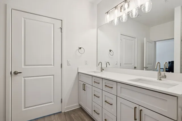 a bathroom with a double vanity sink and a mirror