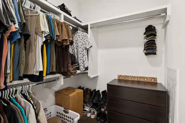 a view of walk in closet with clothes and shoes