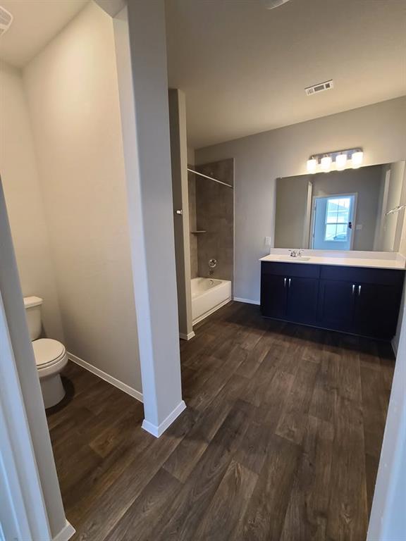 156 Huckleberry Lane Elgin, TX 78621 - Photo 8 of 16 A generous bathroom boasts durable wood-look flooring and a functional tub/shower combination.