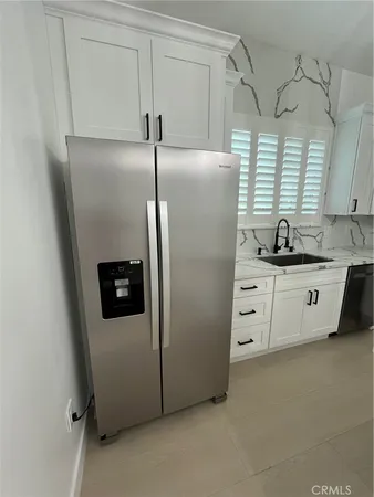 a kitchen with stainless steel appliances a refrigerator sink and cabinets