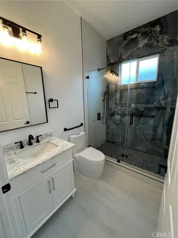 a bathroom with a double vanity sink mirror and shower