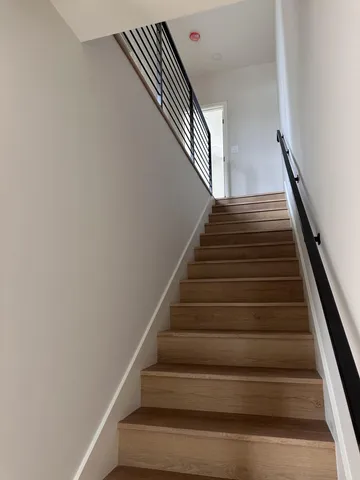 a view of an empty room with wooden floor and closet