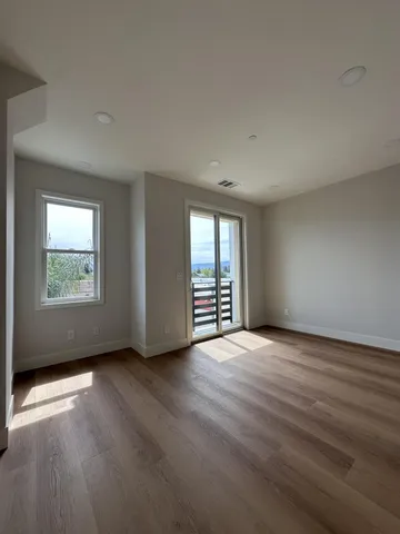 a view of a room with wooden floor and windows