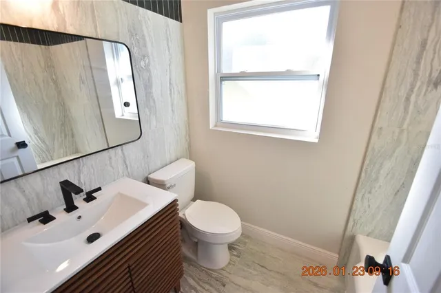 a bathroom with a sink toilet and mirror