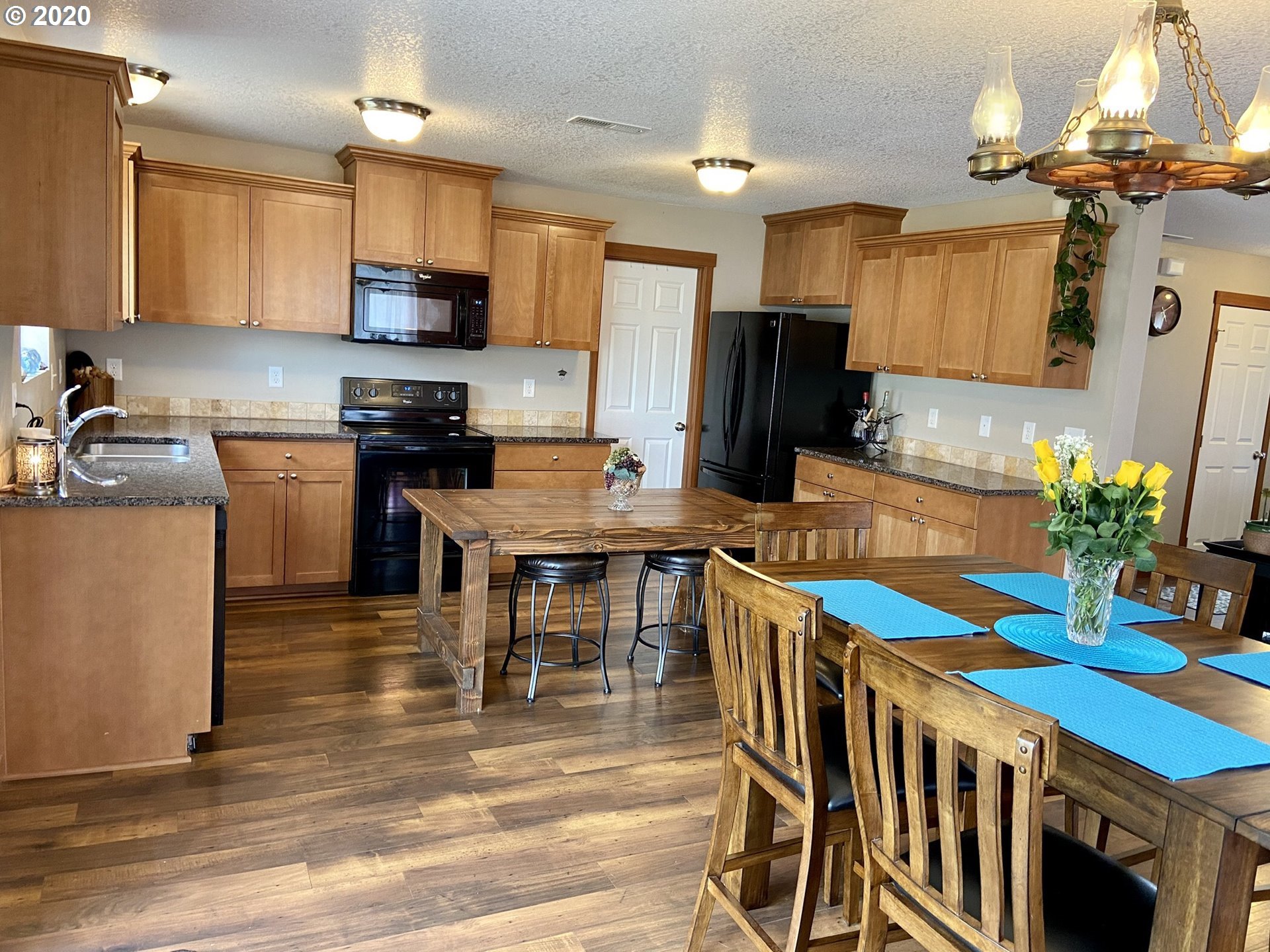 1998 Pruner Road Riddle, OR 97469 - Photo 2 of 22 a kitchen with stainless steel appliances granite countertop a stove top oven a sink a dining table and chairs with wooden floor