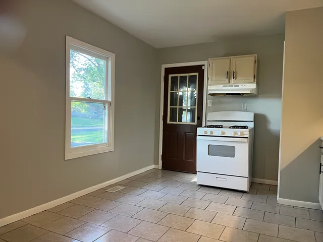 a kitchen with white cabinets and white appliances