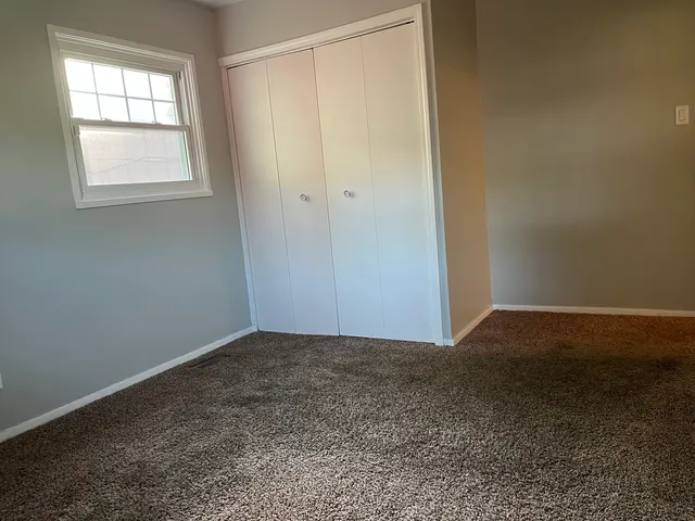 an empty room with windows and closet